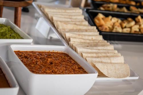 two trays of food on a counter with dip and bread at ALEGRIA Colonial Mar Aquafun in Roquetas de Mar