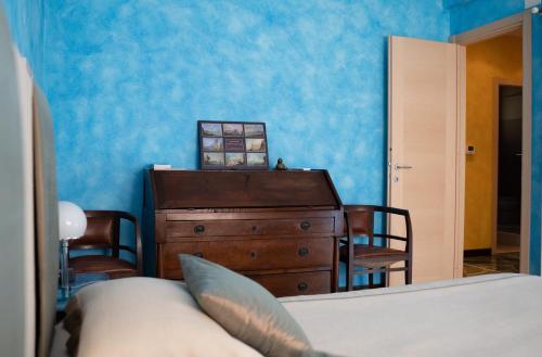 a bedroom with a bed and a dresser and blue walls at La Casa di Potty in Rapallo
