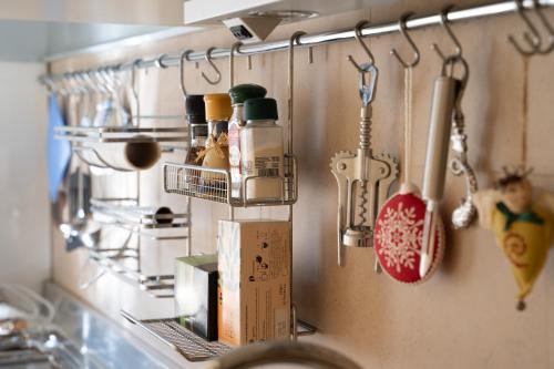 a kitchen counter with utensils hanging on a wall at La Casa di Potty in Rapallo
