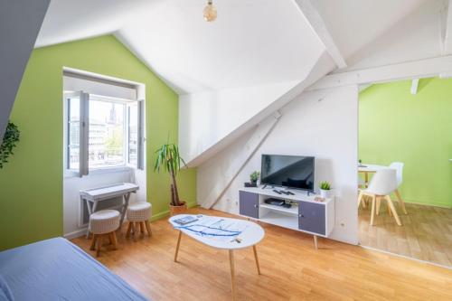 a bedroom with green walls and a bed and a tv at Nid douillet au bord de l'erdre in Nantes