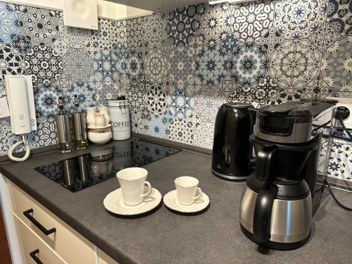 a kitchen with a coffee maker and cups on a counter at Meer Heimat am Steinhuder Meer in Wunstorf