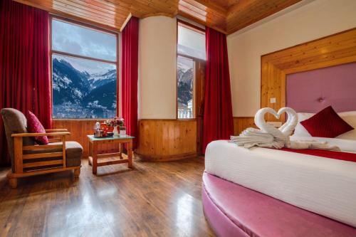 a bedroom with a bed with two swans on it at Sarthak Regency by M K Hospitality,Rangri, Manali,HP,Just 1 kms from Volvo parking in Manāli