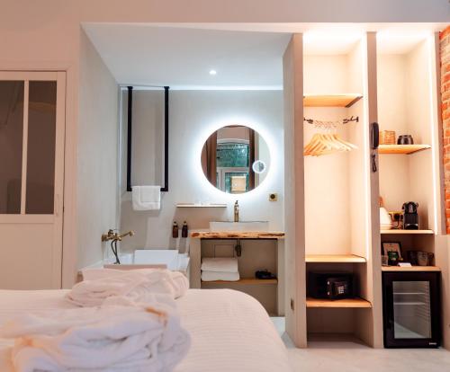 a bedroom with a bed and a sink and a mirror at Hôtel Château Héloïse in Mérélessart