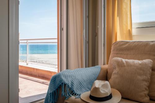a hat sitting on a couch in front of a window at ALEGRIA Colonial Mar Aquafun in Roquetas de Mar