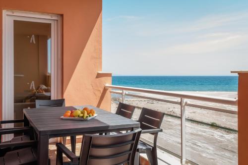 a table with a bowl of fruit on a balcony with the ocean at ALEGRIA Colonial Mar Aquafun in Roquetas de Mar