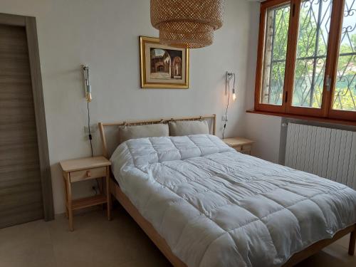 een bed in een slaapkamer met 2 tafels en een raam bij Villa Bagno Santo in Sarteano