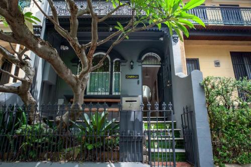 una entrada a una casa con una puerta y un árbol en The Modern Botanist Newtown en Sídney