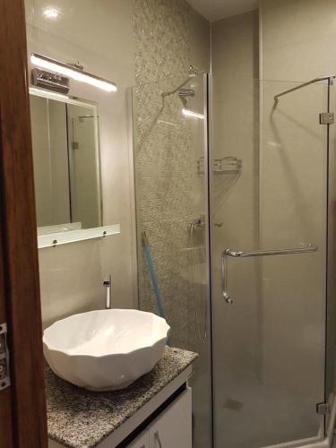 a bathroom with a sink and a glass shower at Уютный номер с видом на горы in Makhinjauri