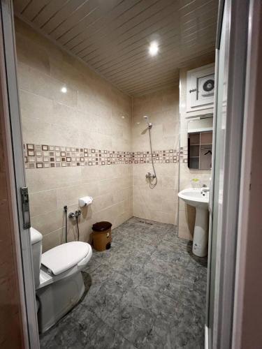 ein Bad mit einem WC und einem Waschbecken in der Unterkunft Hotel Eloued فندق الوادي in Tiksebt