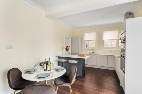 a kitchen with a table and chairs in a room at Richmond - Spacious 2 Bedroom Flat - With Garden in Richmond upon Thames