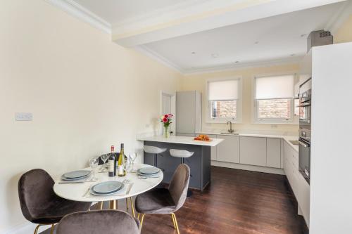 Una cocina con una mesa y sillas en una habitación. en Richmond - Spacious 2 Bedroom Flat - With Garden, en Richmond upon Thames