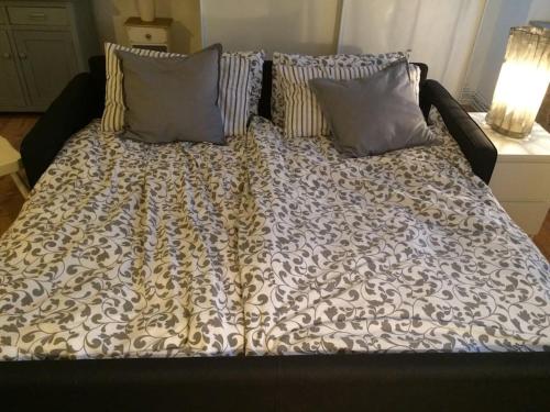 a bed with a black and white blanket and pillows at Jill&Jade's Apartment in Como