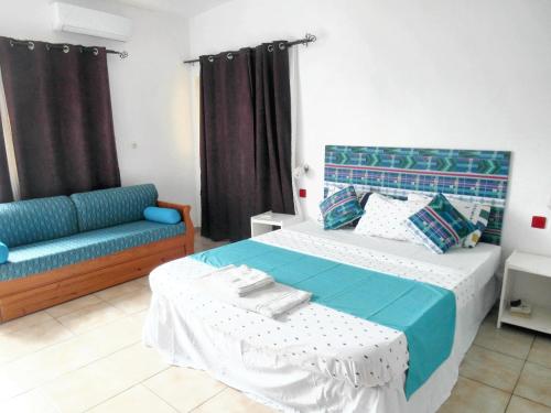 1 dormitorio con 1 cama y 1 sofá en Maison de 4 chambres a Grand Popo a 10 m de la plage avec vue sur la mer piscine partagee et jardin clos, en Grand-Popo