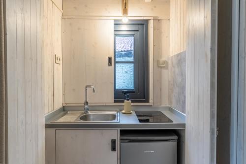 a small kitchen with a sink and a window at Hôtel Quai des Pontis in Cognac