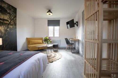 une chambre avec un lit, une chaise et une table dans l'établissement Le Vivier Quevauvillers, à Quevauvillers