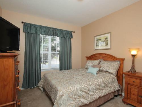 een slaapkamer met een bed, een televisie en een raam bij Tosteth Villa 7766 in Orlando