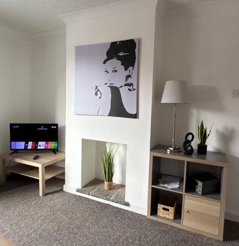 a living room with a fireplace and a tv at 1 Newcastle Street in Crewe