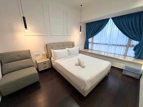 a bedroom with a bed and a chair in it at R&F PRINCESS COVE at ANJU in Johor Bahru