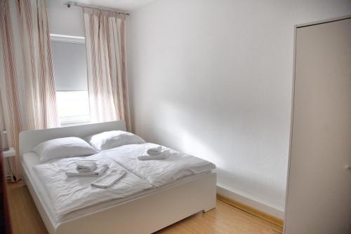 a white bed in a room with a window at Haus JuliaN Wohnung 1 in Ueckermünde