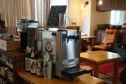 a coffee maker sitting on a counter with bottles of wine at Guest House Moshiripa in Wakkanai