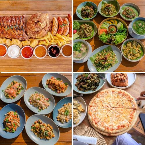 a table with plates of food and a pizza at U villa in Ban Huai Khai