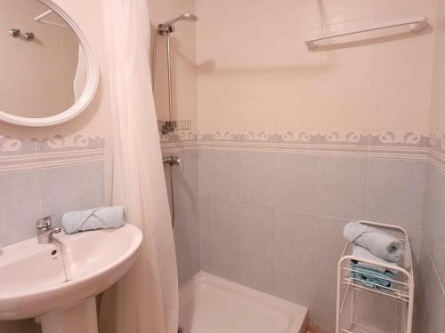Baño blanco con lavabo y espejo en Ardi Casa, en La Mata