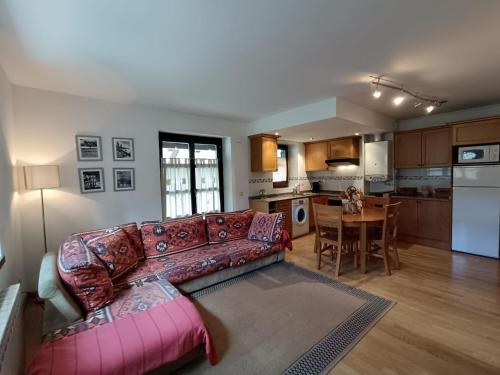 a living room with a couch and a kitchen at InmoCyma Verdiblanco Familias-Valle de Benasque in Benasque