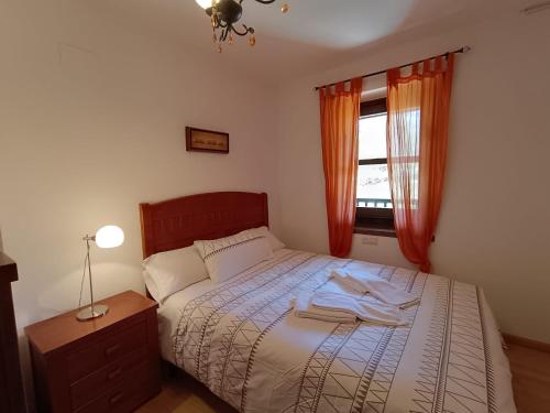 a bedroom with a bed with a robe on it at InmoCyma Verdiblanco Familias-Valle de Benasque in Benasque