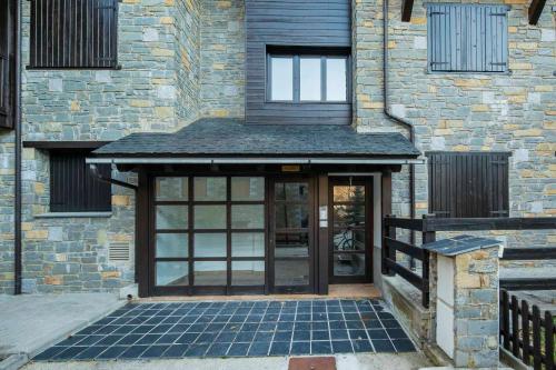 an entry to a brick building with a glass door at InmoCyma Verdiblanco Familias-Valle de Benasque in Benasque