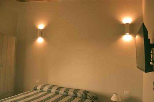 a bedroom with two lights on the wall at B&B SEBA e PAOLA in Sonnino