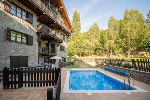 a swimming pool in front of a house at InmoCyma Verdiblanco Familias-Valle de Benasque in Benasque