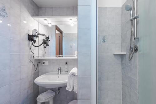 a white bathroom with a sink and a shower at CENTRO HOTEL in Marcon
