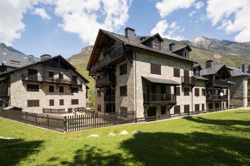 a large stone building with mountains in the background at InmoCyma Verdiblanco Familias-Valle de Benasque in Benasque