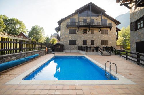a swimming pool in front of a large house at InmoCyma Verdiblanco Familias-Valle de Benasque in Benasque