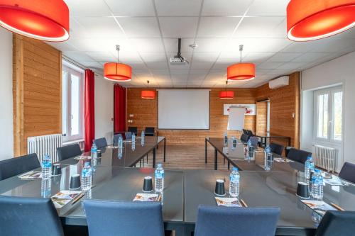 a conference room with a long table and blue chairs at Hôtel Quai des Pontis in Cognac