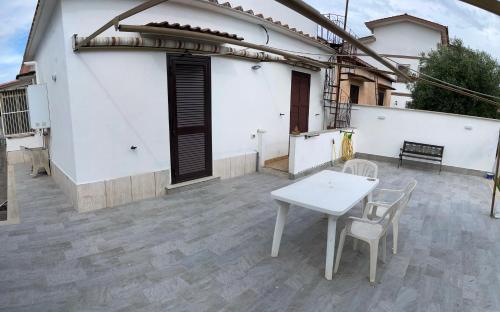 a white table and chairs on a patio at Villa Elvira in Torvaianica