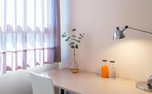a table with a vase and two bottles on it at La City Mercado in Alicante
