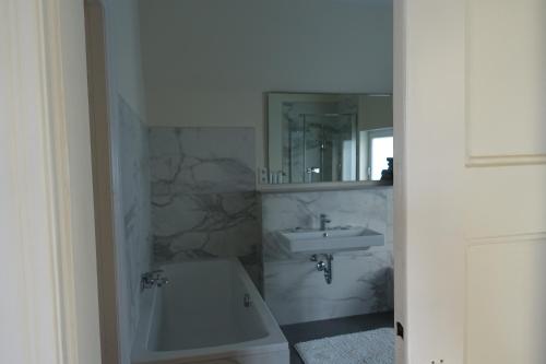 ein Badezimmer mit einem Waschbecken, einem WC und einem Spiegel in der Unterkunft Villa mit 5 Schlafzimmer in Bremen
