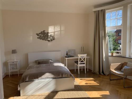 1 dormitorio con cama, escritorio y ventana en Villa mit 4 Schlafzimmer, en Bremen