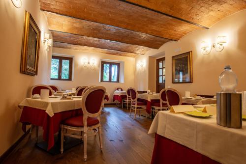 サン・ジミニャーノにあるTorciano Hotel Vecchio Asiloのダイニングルーム(テーブル、椅子付)