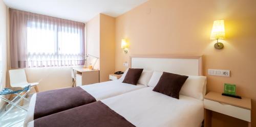 ein Hotelzimmer mit einem weißen Bett und einem Fenster in der Unterkunft La City Mercado in Alicante