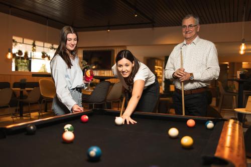 a group of people standing around a pool table at Green Park Hotel Brugge in Bruges