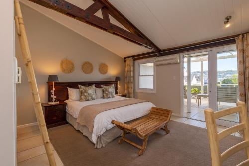 a bedroom with a large bed and a balcony at The Lofts Boutique Hotel in Knysna