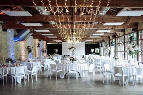 a banquet hall with white tables and chairs at Hôtel Quai des Pontis in Cognac