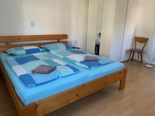 a bedroom with a large bed with blue sheets and blue pillows at Fewo Max in Münchweier