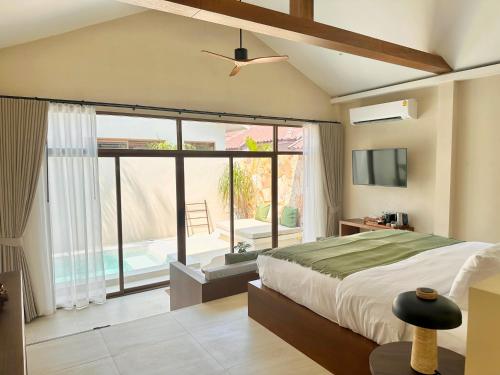 um quarto com uma cama e uma grande janela em Malaya Villa Kohlarn em Ko Larn