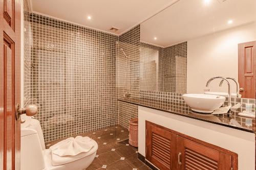 a bathroom with a sink and a toilet and a sink at Kamala Beach Estate Resort - SHA Extra Plus in Kamala Beach