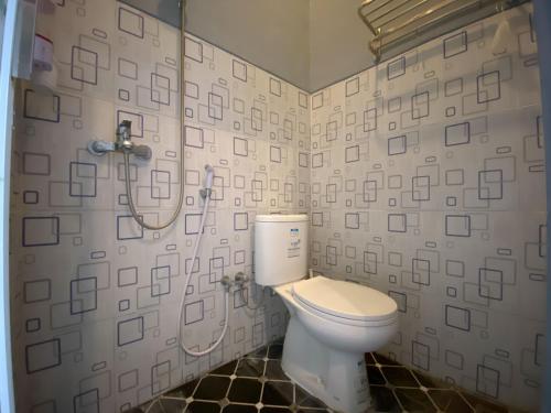 a bathroom with a toilet and a shower at Duta Elite Kostel Syariah near RSUD Caruban Redpartner in Madiun