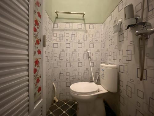 a bathroom with a white toilet in a room at Duta Elite Kostel Syariah near RSUD Caruban Redpartner in Madiun