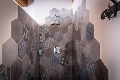 een badkamer met een betegelde muur en een douche bij Agriturismo Le Pozze in Poppi